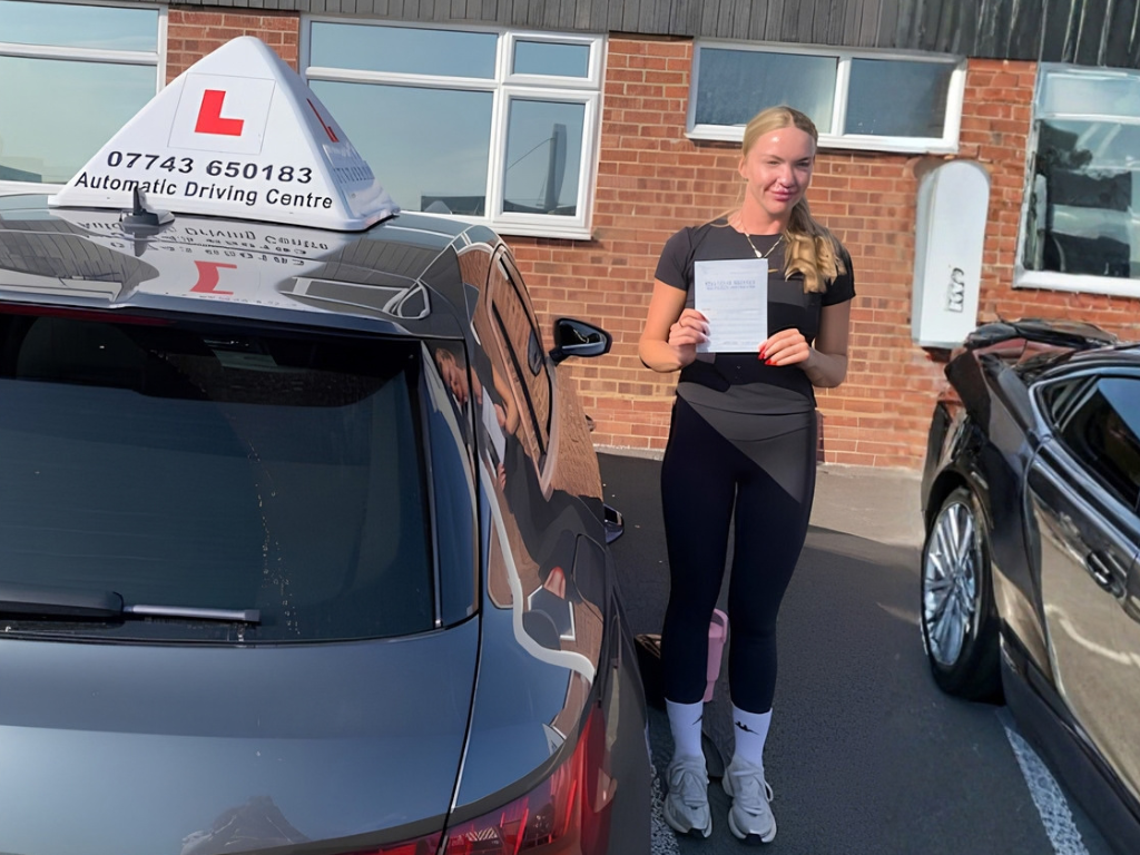 newly passed learner student holding certificate in front of learner car